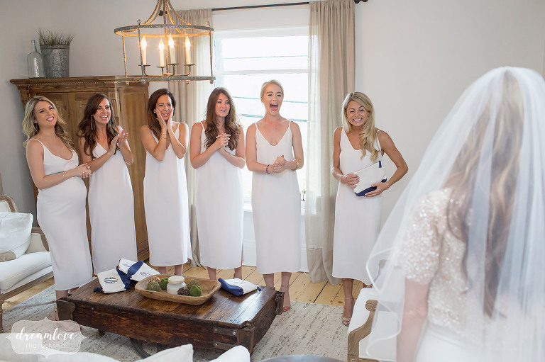 These happy bridesmaids, dressed all in white, are elated to see the bride in her dress for the first time at the Farm Home in Stowe, VT.