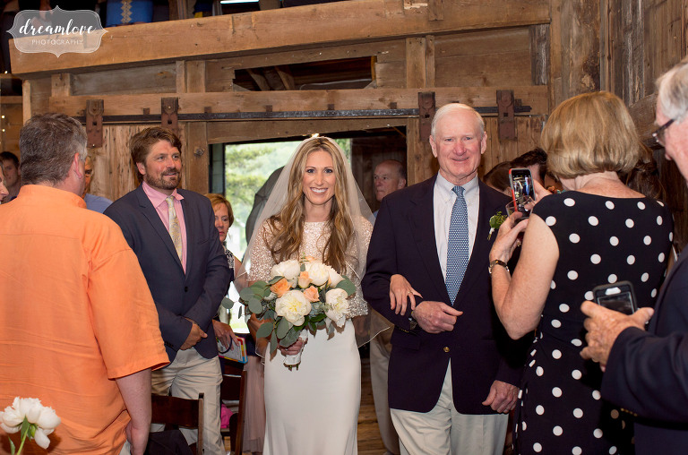 The bride and her father walk into the ceremony at the Comfort Farm in Stowe.