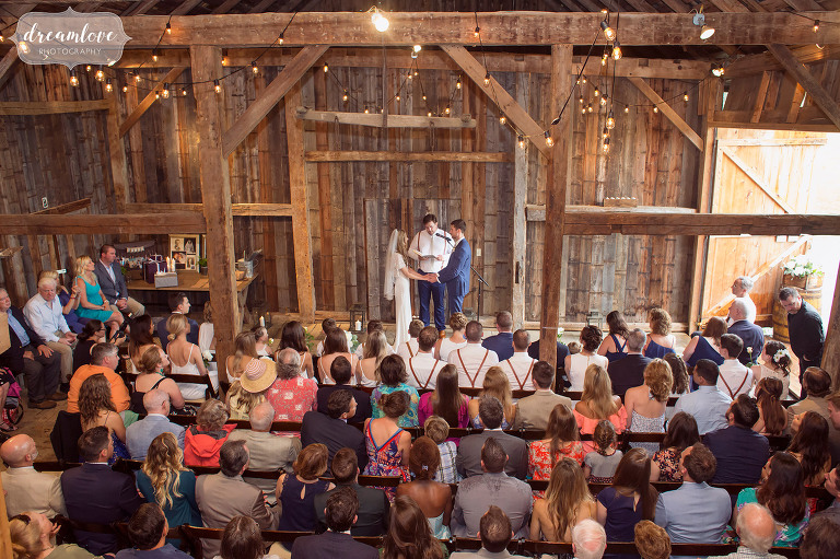 Here is an overall view of the inside of the Comfort Farm barn in Stowe during a wedding ceremony with a large guest list.