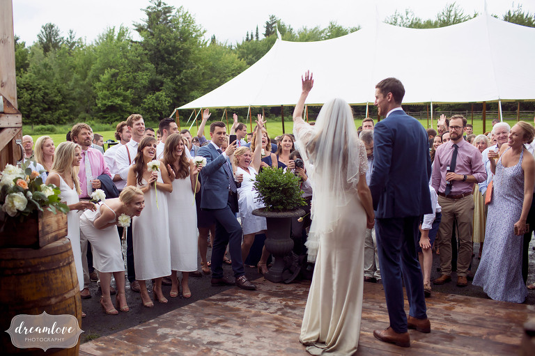 Bride and groom wave to guests at their Comfort Farm wedding in Stowe.
