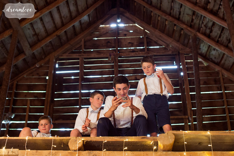 The ringbearers in their suspenders hang out in the loft of the Stowe Comfort Farm barn during a rainy wedding in Stowe.