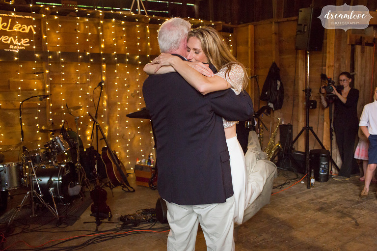 Lisa Mara hugs her dad during the father daughter dance at her barn wedding in Stowe, VT.