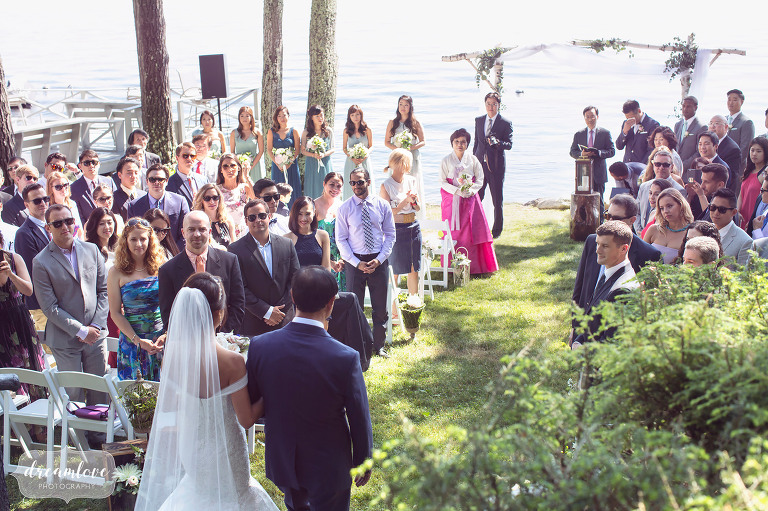 The bride and her father walk down the aisle at this lakeside ceremony in Wolfeboro, NH.