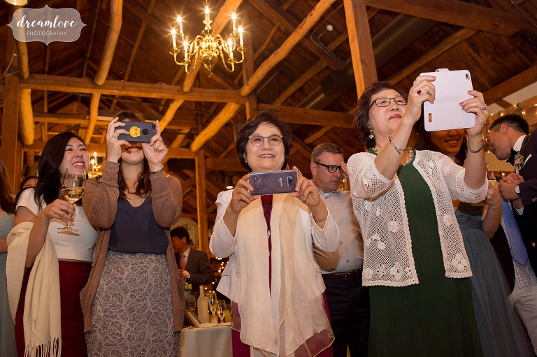 Funny wedding photos of all of the Korean guests taking photos with their cell phones during the father daughter dance at the Inn on Main in NH.