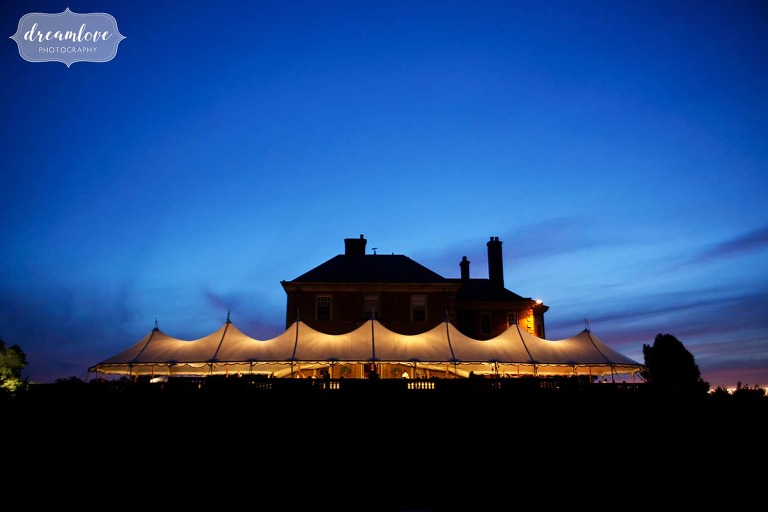 Twilight view with blue light of the reception tent set up outside of the Crane Estate venue on Castle Hill.