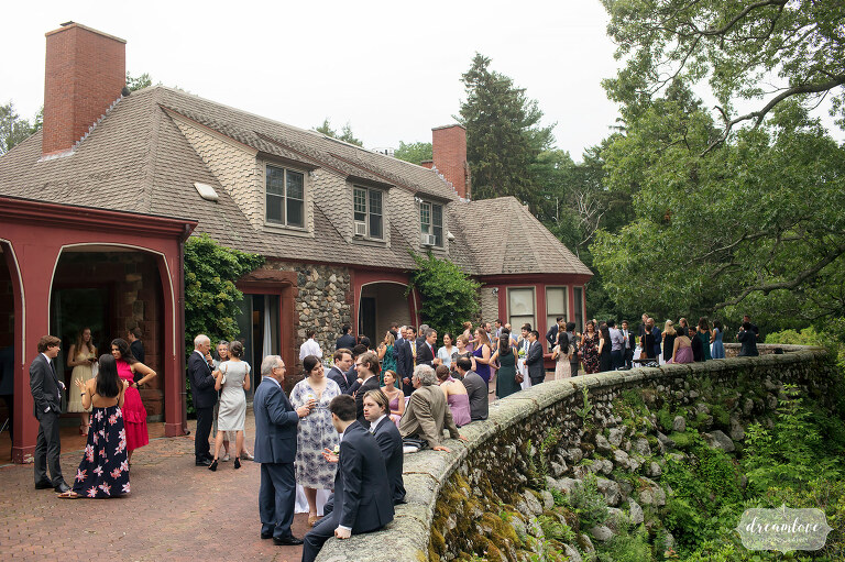 Wedding guests enjoy cocktails on winding patio behind the Moraine Farm Estate.