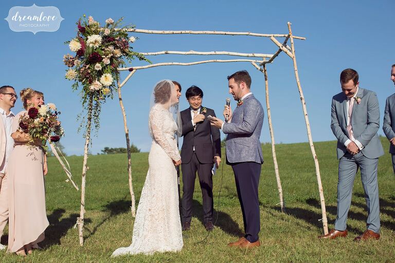 The groom reads his vows to the bride during their September wedding under a birch wood chuppah with flowerkraut flowers.