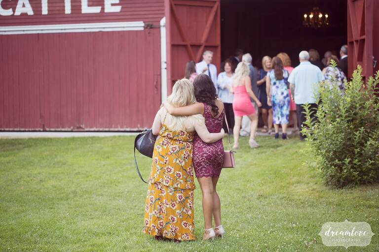 Candid wedding photos of guests hugging at Bishop Farm.