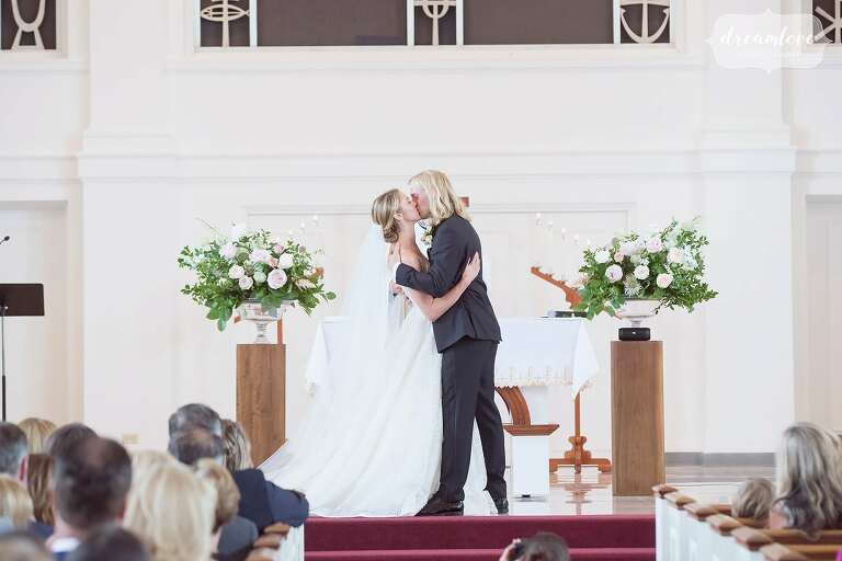The bride and groom kiss on the alter at Rooke Chapel on Bucknell University.