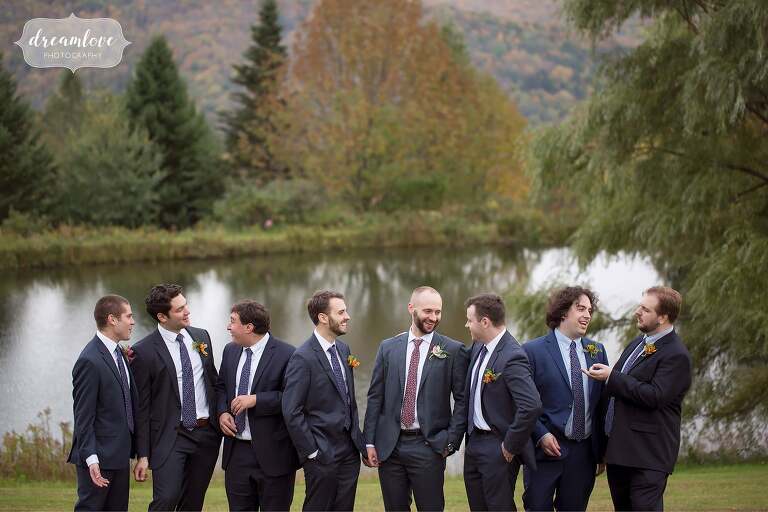 The groomsmen laugh in front of a pond for this Catskill backyard wedding.