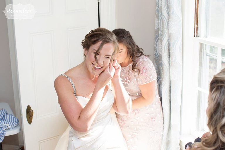 The bride puts her earrings on at the Windsor Mansion wedding venue.