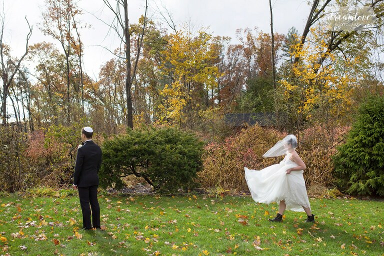The bride walks toward groom in hiking boots for the first look in Newton, MA.