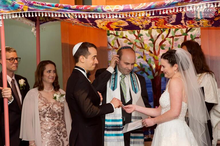 Emotional Jewish wedding under colorful batik chuppah in Boston.