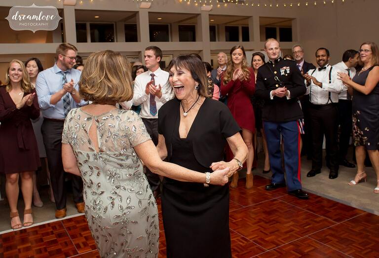 Mother of the bride dances with friend at Boston Jewish wedding.