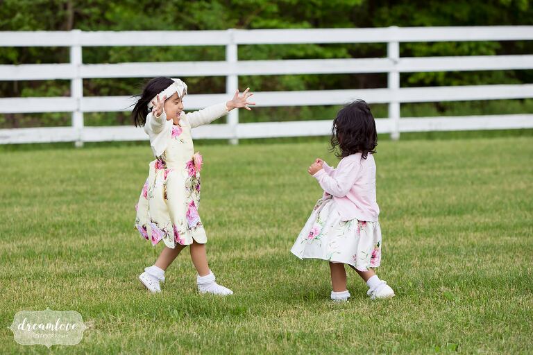 Girls playing by horse fence at barn wedding in Hudson Valley.
