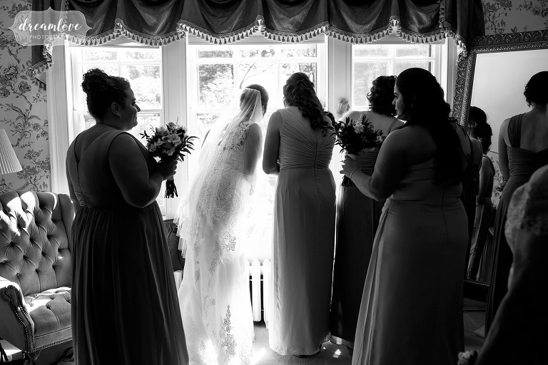 Bridesmaids looking out windows at Bradley Estate.