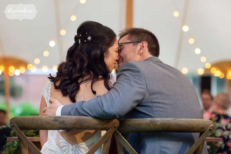 Sexy photo of bride and groom almost kissing under the tent with cafe lights at Boston wedding.