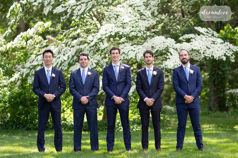 Groomsmen pose in gardens at Boston estate wedding venue.