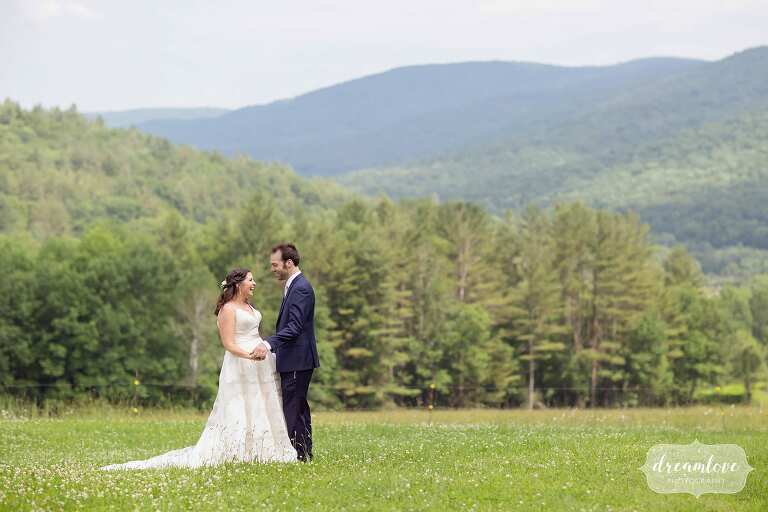 Bride and groom laugh in the field at this rustic Western Mass wedding venue.