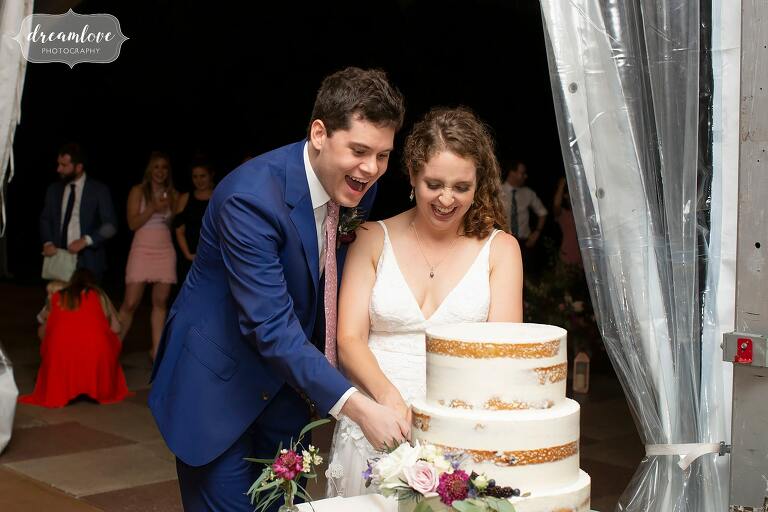 Bride and groom cut the cake at this tented garden wedding in Philly.