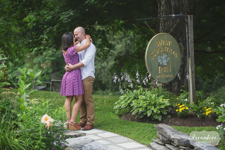 Couple kissing in front of West Mountain Inn during engagement session.