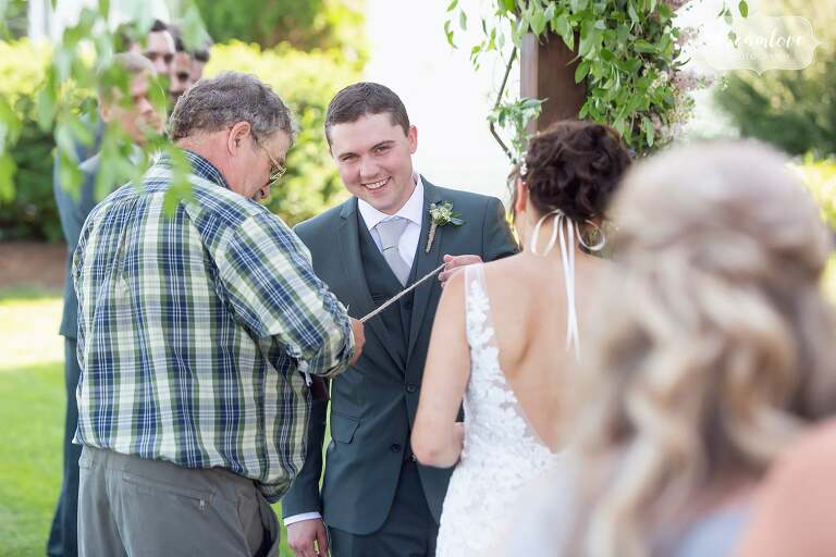 Groom laughing during ceremony at Warfield House Inn.