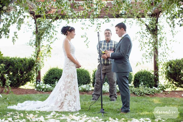 Bride and groom read vows outside at Warfield House Inn wedding venue.