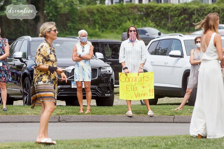 Covid wedding guests in masks with signs in CT.
