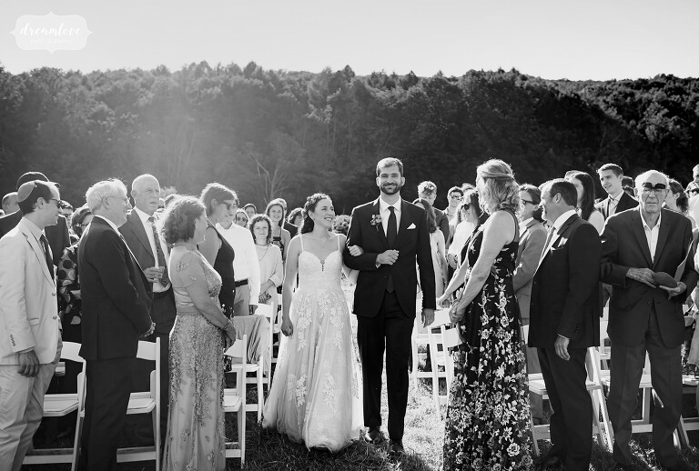 Les mariés entrent dans une cérémonie en plein air à Cricket Creek Farm.