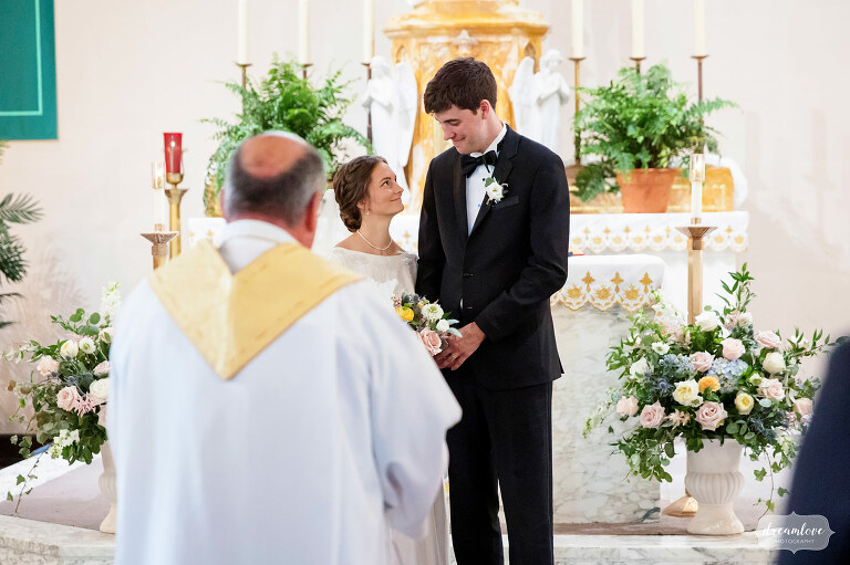Bride and groom look at each other during Sacred Heart wedding ceremony in MA.