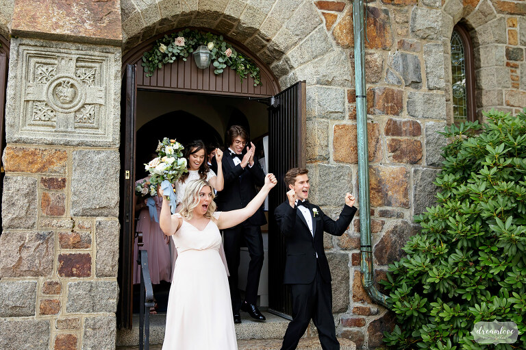 Wedding party cheers while exiting Sacred Heart church in Manchester, MA.