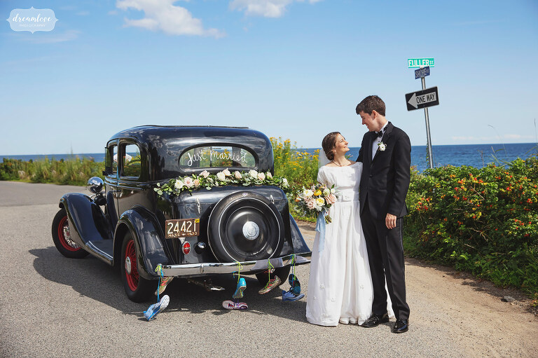 Bride and groom pose in front of 1930's Chevy at Magnolia Beach in Gloucester, MA.