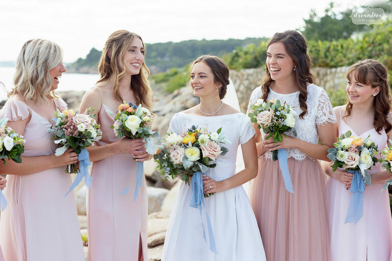 Bride talks with her bridesmaids at Magnolia Beach in Manchester, MA.