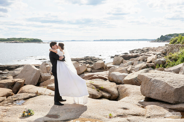 Bride and groom kissing on Magnolia Beach on the north shore of MA.