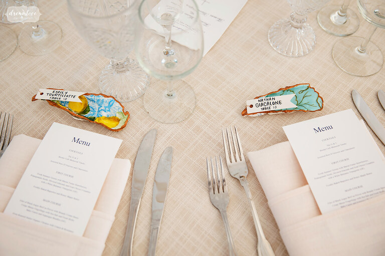 Bride used cocktail napkins to modpodge oyster shells as escort cards at Connemara Farm.