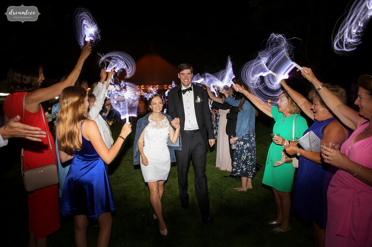 Bride and groom exit wedding reception with fiber optic flash lights.