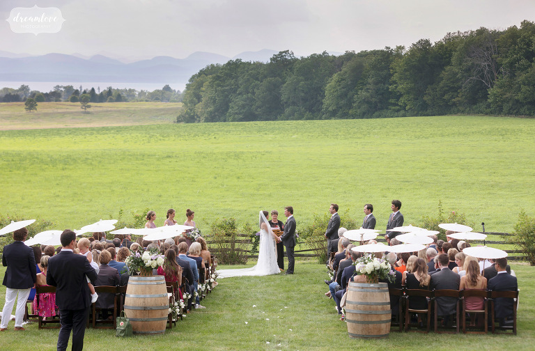 Brick House at Shelburne Farms wedding ceremony in the field with mountains.