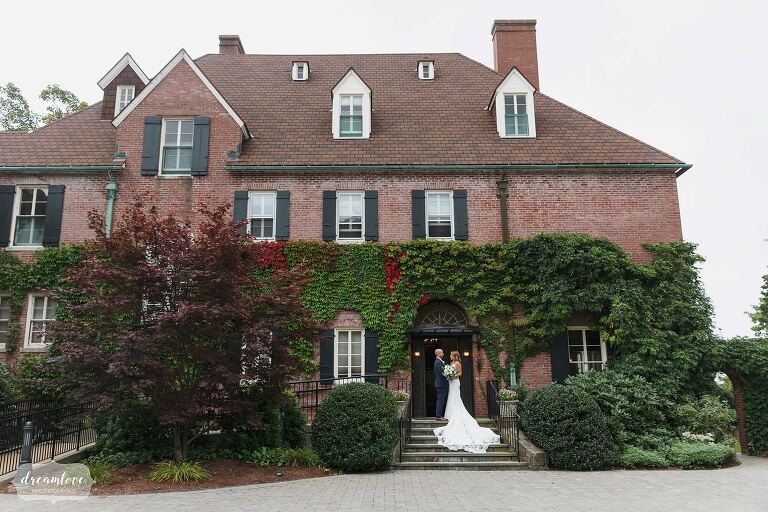 Bride and groom stand on steps of Misselwood wedding venue in Beverly, MA.