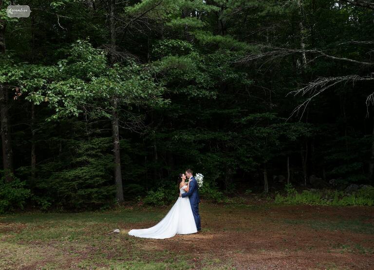 Bride and groom hug at Whiteface Hollow Barn wedding venue in NH.