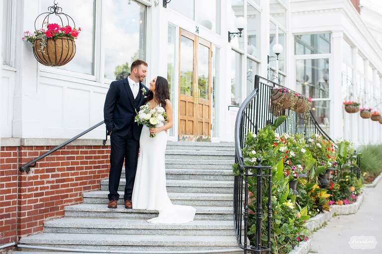 Bride and groom stand on steps to Hotel Northampton in MA.